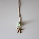 Small metal golden star with green flowers