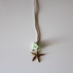 Small metal golden star with green flowers