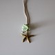 Small metal golden star with green flowers